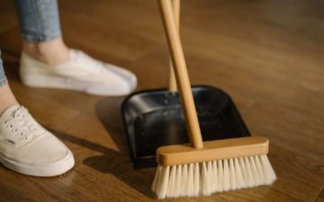 a person using a a broom and a dust pan