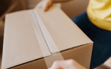 man tapes a moving-box