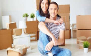 couple moving with packed boxes around