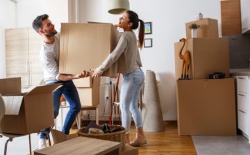 A man and a woman holding a moving box