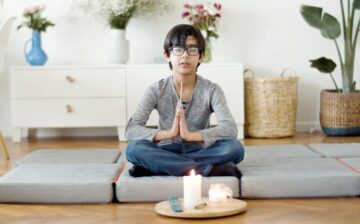 a person seats on pillows on the floor