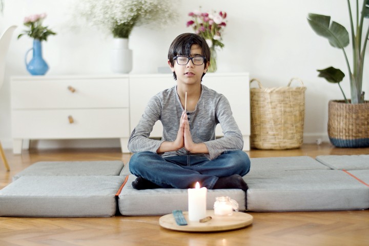  a person seats on pillows on the floor 