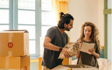 a couple are packing moving boxes