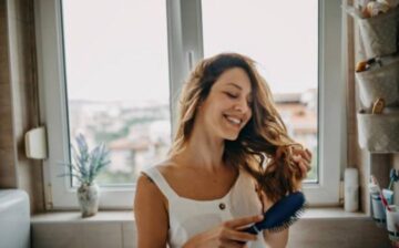 a woman brushes her hair after Hair Transplant