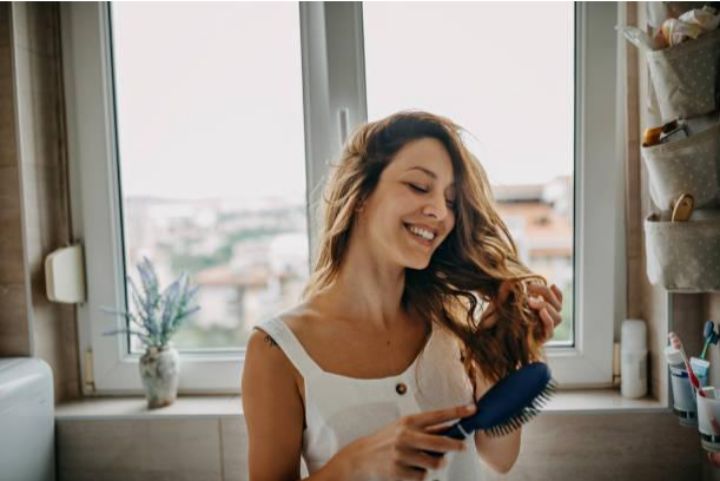 a woman brushes her hair after Hair Transplant 