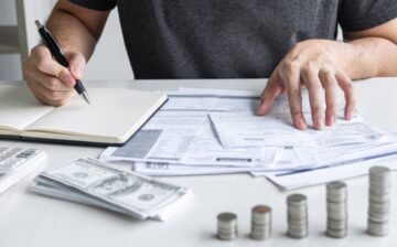 a person calculates Moving Expenses with cash around him