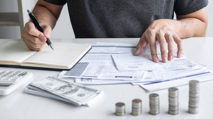 a person calculates Moving Expenses with cash around him
