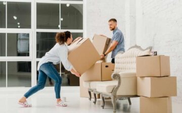 a couple is lifting moving boxes