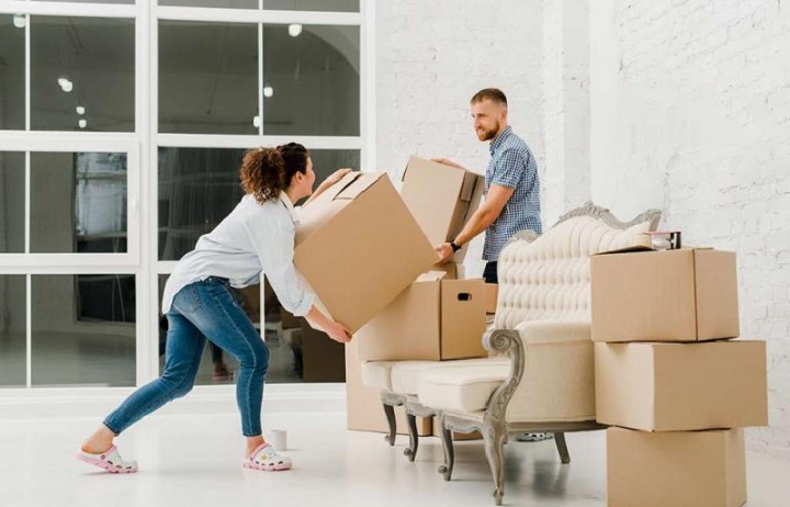 a couple is lifting moving boxes