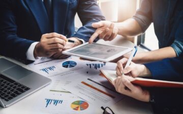 employees writing Business Strategies on note book