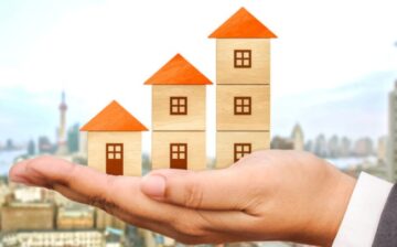 logs of small houses on a person's hand