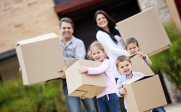 a family is holding moving boxes