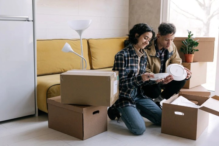 couple taking dishes out of moving boxes