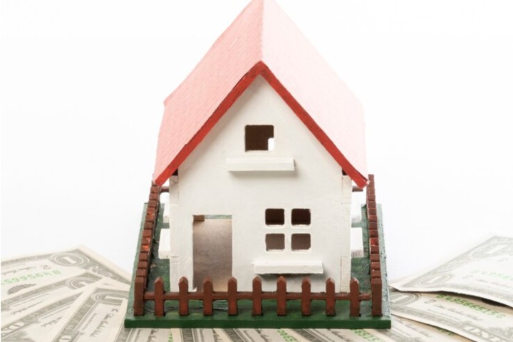 house on scale with bills around