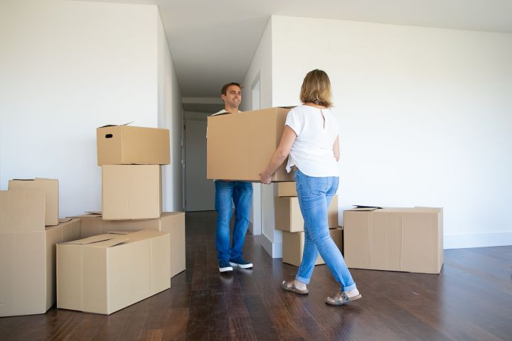 couple holding moving boxes