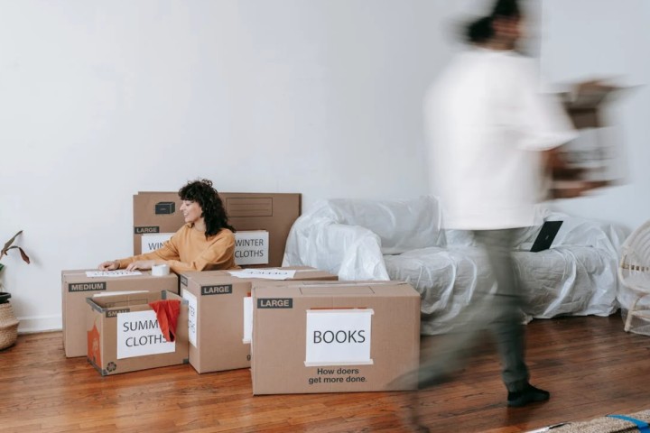 a couple is moving packed boxes