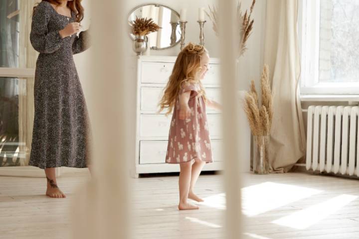 girl dancing at home with her mother