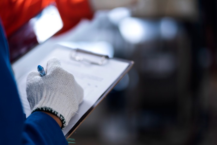man is writing on a clipboard