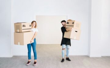 a couple holding moving boxes